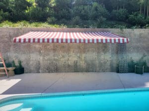 Custom red and white striped awning at a pool